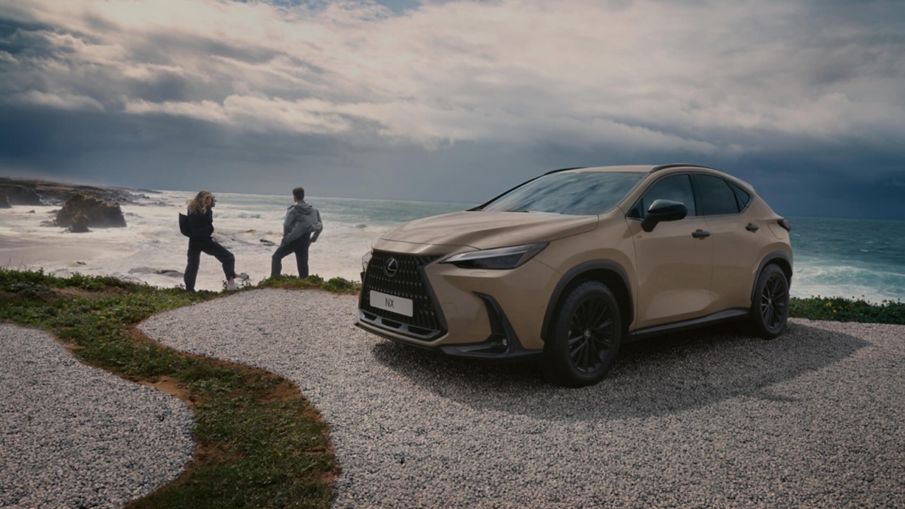 Du žmonės stovi prie pastatyto Lexus NX